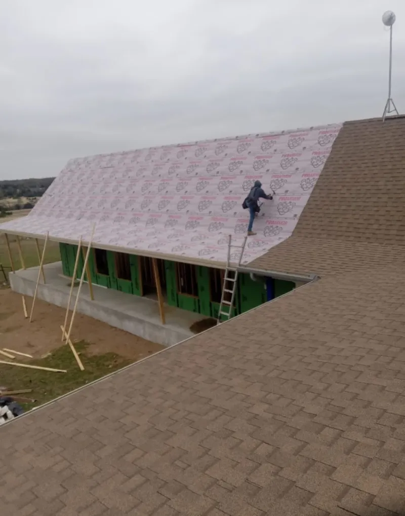 Worker preparing underlayment for a metal roof installation in Seneca Falls